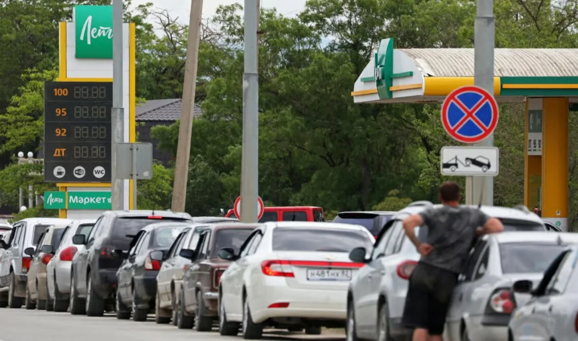 Довга черга автомобілів біля заправки Лето з табло цін