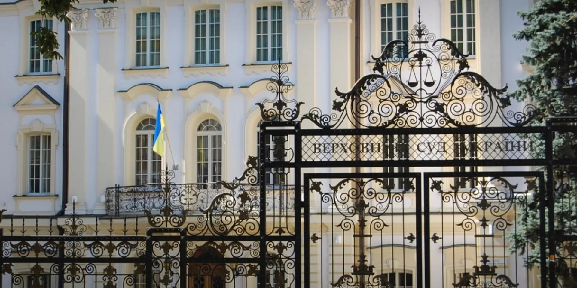 Фасад Верховного Суду України з прапором і кованою брамою
