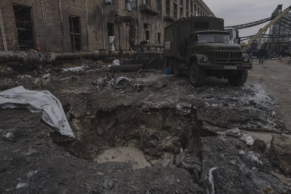 Зруйнована промислова будівля, воронка та військовий вантажівка після обстрілу
