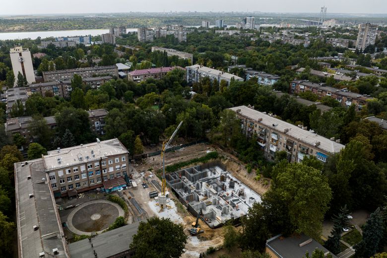 Аерознімок будівельного майданчика з краном і бетонним фундаментом серед житлових будинків у Змієві